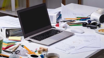 Laptop on a cluttered home desk